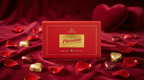 Red box of Belgian Passion chocolates with gold hearts and red fabric background